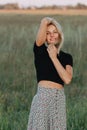 Portrait of a young blond woman in a field playing with her hair Royalty Free Stock Photo