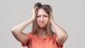 Portrait of young blond woman in panic grabbing her head in fear or frustration. Stress and mental health Royalty Free Stock Photo