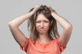 Portrait of young blond woman in panic grabbing her head in fear or frustration. Stress and mental health Royalty Free Stock Photo