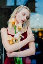 Portrait of the young blonde attractive woman with the iris flowers behind the glass Royalty Free Stock Photo