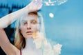 Portrait of the young blonde attractive woman with the iris flowers behind the glass Royalty Free Stock Photo