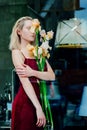 Portrait of the young blonde attractive woman with the iris flowers behind the glass Royalty Free Stock Photo