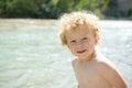 Portrait of a young blonde boy playing in water Royalty Free Stock Photo