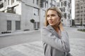 Portrait of young blonde businesswoman in gray suit walking in the city Royalty Free Stock Photo