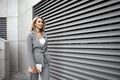 Portrait of young blonde businesswoman in gray suit walking in the city Royalty Free Stock Photo