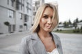 Portrait of young blonde businesswoman in gray suit walking in the city Royalty Free Stock Photo