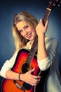 Portrait of young blonde guitar player woman