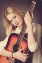 Portrait of young blonde guitar player woman