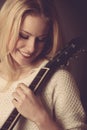 Portrait of young blonde guitar player woman