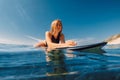 Portrait of young surf girl in ocean during surfing. Beauty surfer woman lies on surfboard Royalty Free Stock Photo