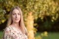 Portrait of a young blonde woman against a defocused landscape. Autumn color shade Royalty Free Stock Photo