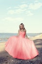 Young blonde woman at the beach with red tulle ball dress Royalty Free Stock Photo