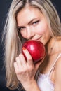 Portrait of young blonde woman with a big red apple Royalty Free Stock Photo