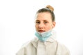 Portrait of young blonde woman with downcast medical mask on grey background Royalty Free Stock Photo
