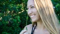 Cute close portrait of a young blonde woman face smiling laughing with blue clear eyes and a daisy flower isolated Royalty Free Stock Photo