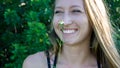 Cute close portrait of a young blonde woman face smiling laughing with blue clear eyes and a daisy flower isolated Royalty Free Stock Photo