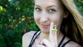 Cute portrait of young blonde woman face smoking daisy flower weed smiling with blue clear eyes isolated in nature Royalty Free Stock Photo