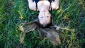 Portrait young blonde woman laying in the grass with long hair and blue eyes Royalty Free Stock Photo