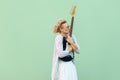 Portrait of young blonde woman in white shirt, skirt, and striped blouse with eyeglasses standing, holding and kissing her lovely Royalty Free Stock Photo