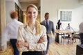 Portrait of young blonde woman in a busy modern workplace Royalty Free Stock Photo