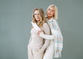 Portrait of young blonde women friends in sportswear on background of grey wall Royalty Free Stock Photo