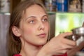 Portrait of a young blue-eyed woman 20-25 years old pouring coffee into a cup from a coffee machine, close-up, selective focus, ga Royalty Free Stock Photo