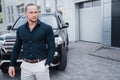 Portrait of a young bodyguard near the car. He performs dangerous work