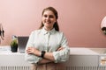 Portrait of a young boutique owner standing at counter. Smiling female in her clothing store