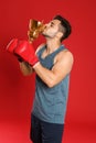 Portrait of young boxer kissing gold trophy cup on red Royalty Free Stock Photo