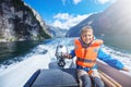 Portrait of young boy driving the motorboat on the Geirangerfjord, Norway. Royalty Free Stock Photo