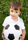 Portrait, young boy and hold with football in garden for fun game, exercise and fresh air in Peru. Closeup, innocent and Royalty Free Stock Photo