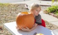 Portrait of a young boy outside carving pumpkins Royalty Free Stock Photo