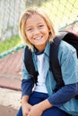 Portrait Of Young Boy With Rucksack Sitting In Park Royalty Free Stock Photo