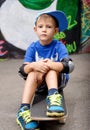 Portrait of Young Boy Sitting on Skateboard Royalty Free Stock Photo