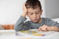 Portrait of young boy struggling with his homework at home. Children education concept Royalty Free Stock Photo