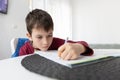 Portrait of young boy struggling with his homework at home. Children home education concept. Distance learning Royalty Free Stock Photo