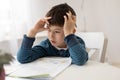 Portrait of young boy struggling with his homework at home. Children home education concept. Distance learning Royalty Free Stock Photo