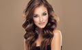 Brown haired woman with voluminous, shiny and curly hairstyle.Long hair and makeup. Royalty Free Stock Photo