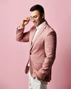 Portrait of young brunet businessman, charismatic art dealer in official suit stands taking off, putting on his glasses Royalty Free Stock Photo