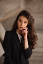 Portrait of young brunet woman standing outside in black jacket, jeans, white top Royalty Free Stock Photo