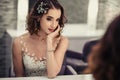 Portrait of young brunette bride woman in dressing room with wedding jewelry and dress