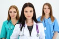 Portrait of young brunette female doctor surrounded by medical team Royalty Free Stock Photo