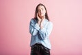 Portrait of a young brunette girl with closed eyes in the studio on a pink background. Royalty Free Stock Photo