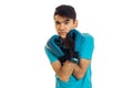 Portrait of young brunette man in blue gloves practicing boxing and looking at the camera isolated on white background Royalty Free Stock Photo
