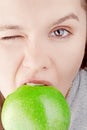 Portrait young brunette woman biting green apple Royalty Free Stock Photo