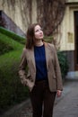 Portrait young brunette woman in brown suit standing in front of building Royalty Free Stock Photo