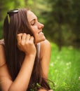 Portrait of a young brunette woman enjoying the lying on the gr