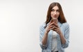 Portrait of a young brunette woman looking at the smartphone in her hands. Studio shot white background Royalty Free Stock Photo