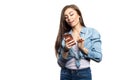 Portrait of a young brunette woman looking at the smartphone with surprised expression on her face against white background Royalty Free Stock Photo