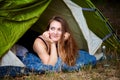 Young brunette woman lying in tent and looking outside Royalty Free Stock Photo